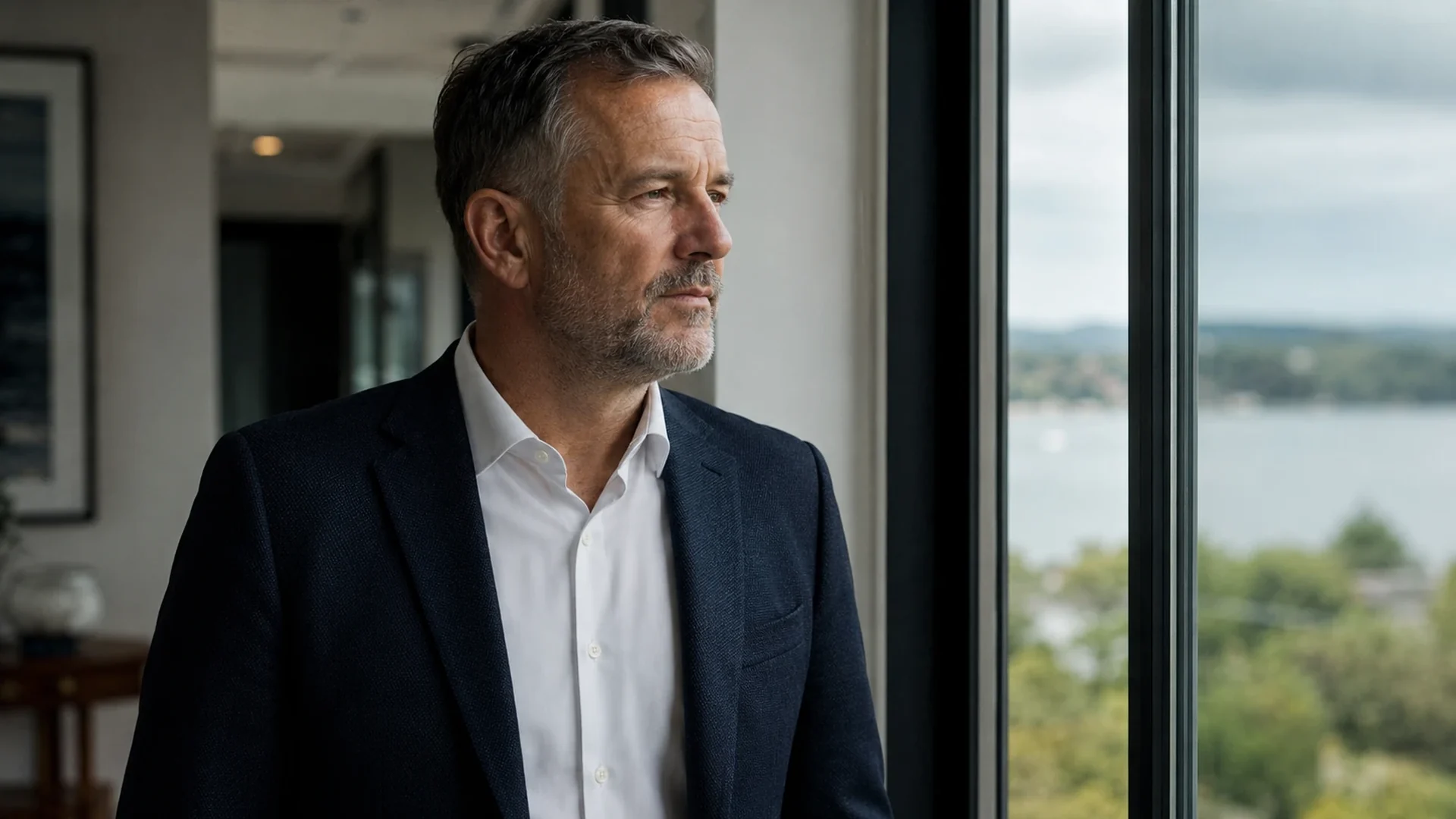 A man looking out at a grey horizon, expression flat
