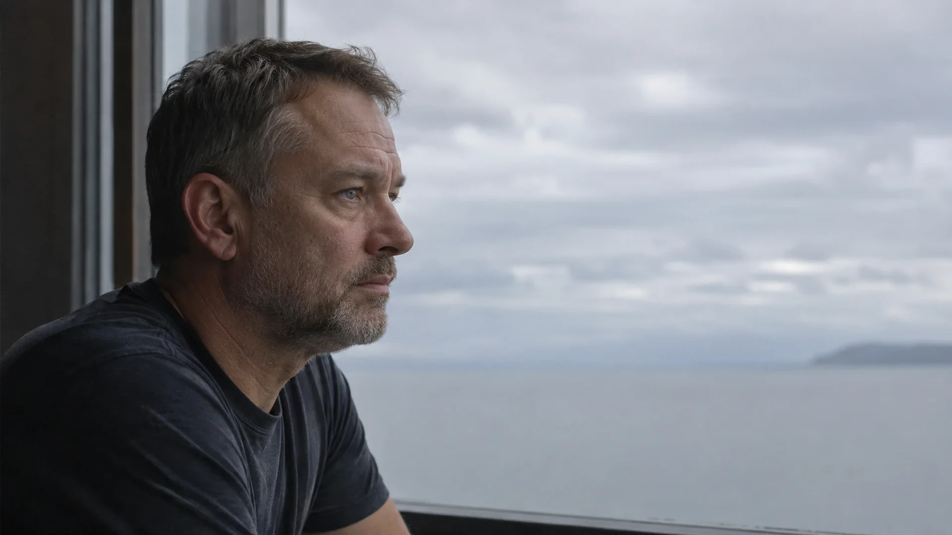A successful man alone at a window, looking out at the view