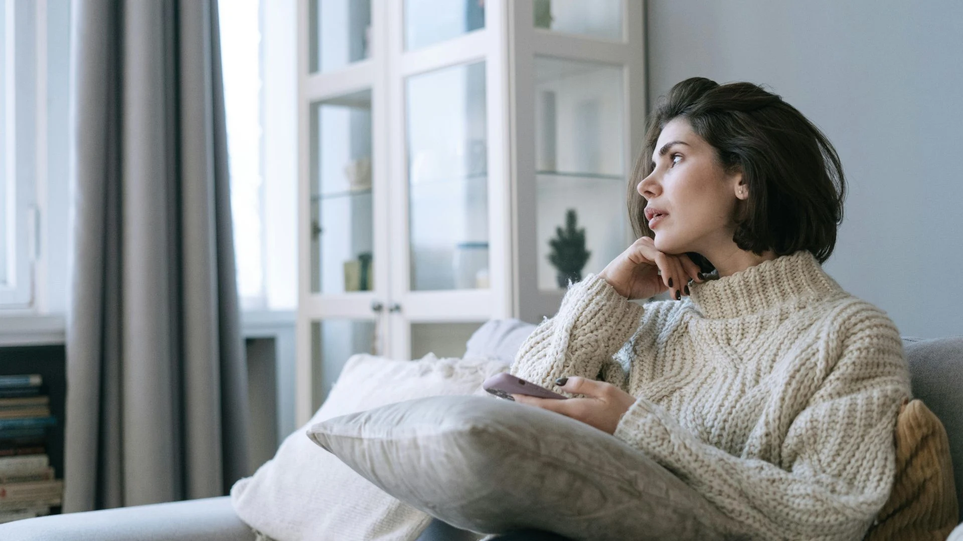 Person sitting alone looking out a window