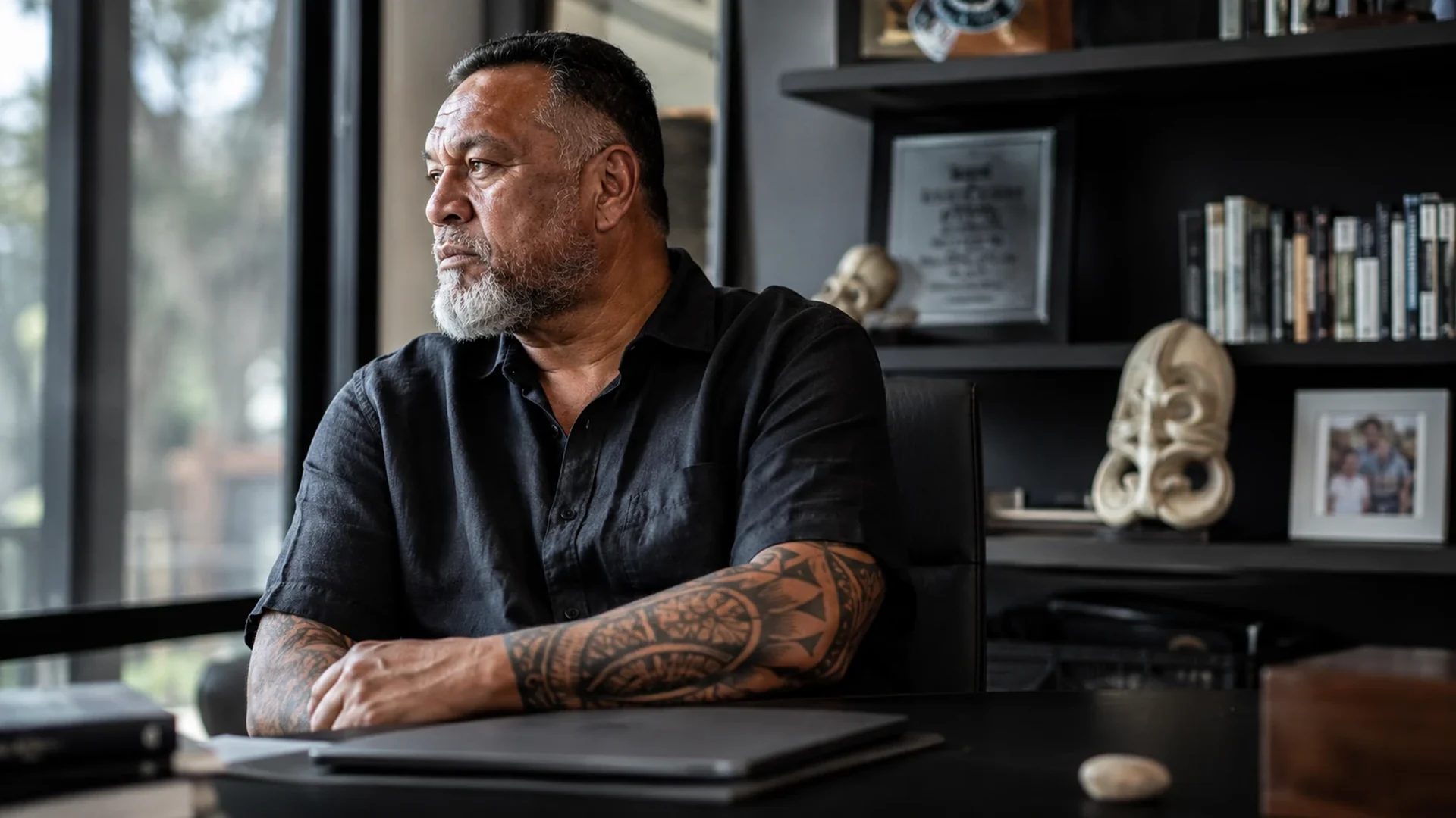 A man at a desk of achievements, staring past them