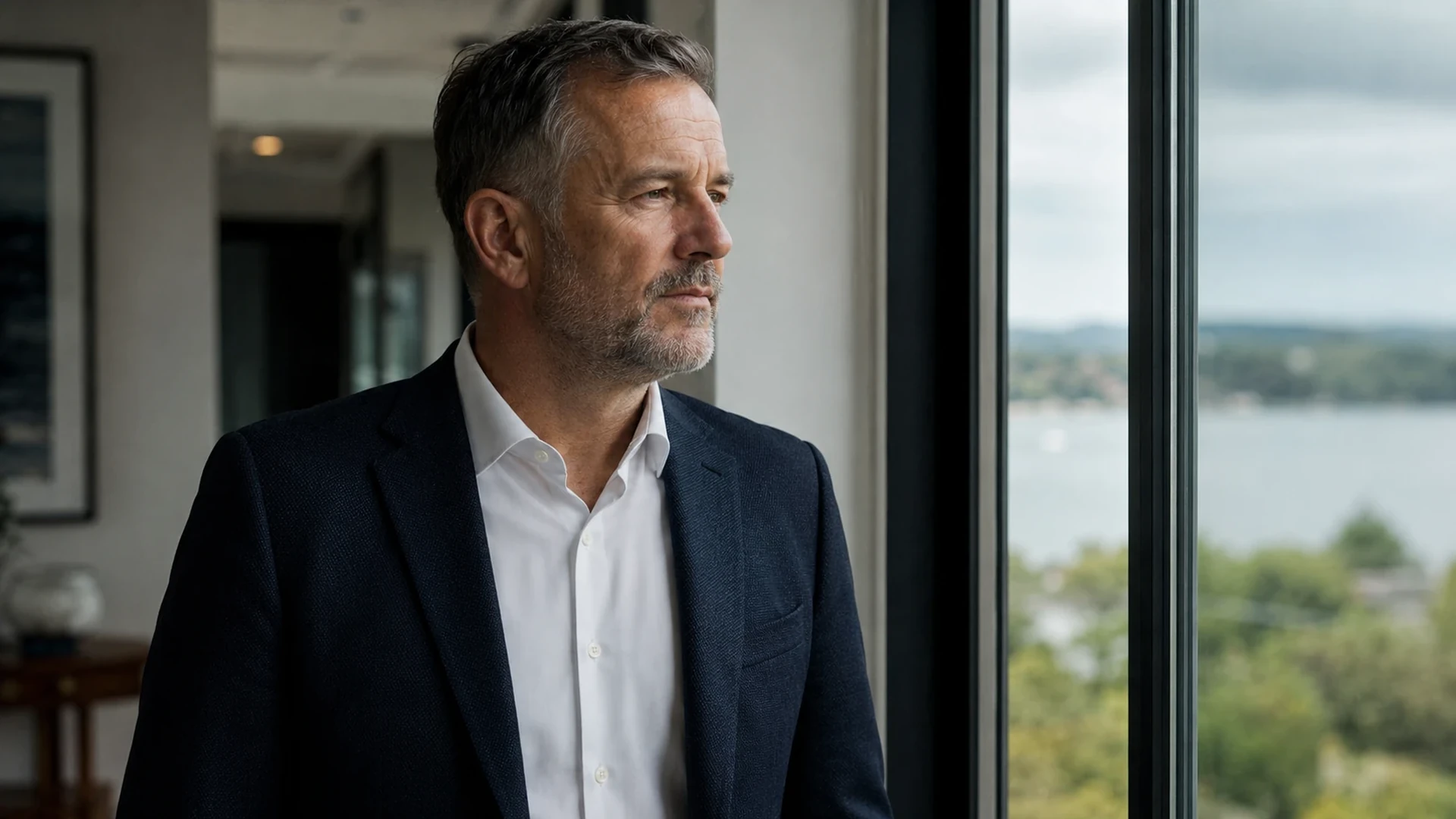 A person in a grey, in-between moment by a window